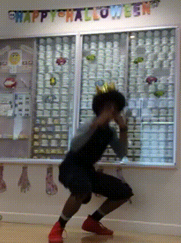 Person exercising in orthodontic office with colorful decorations and display cases on walls.