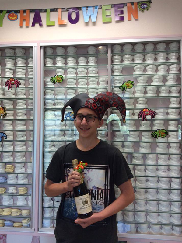 Person holding orthodontic product in front of shelving display with Halloween decorations at Brenn Orthodontics.
